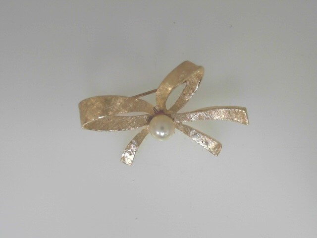 Estate 14 Karat Yellow Gold Ribbon Brooch 5.50 nmm Round Pearl
4.1grm

Very Good Condition

Please keep in mind that when buying Estate items you are purchasing something that is pre-loved.  Most Estate items show signs of wear, but that is also what